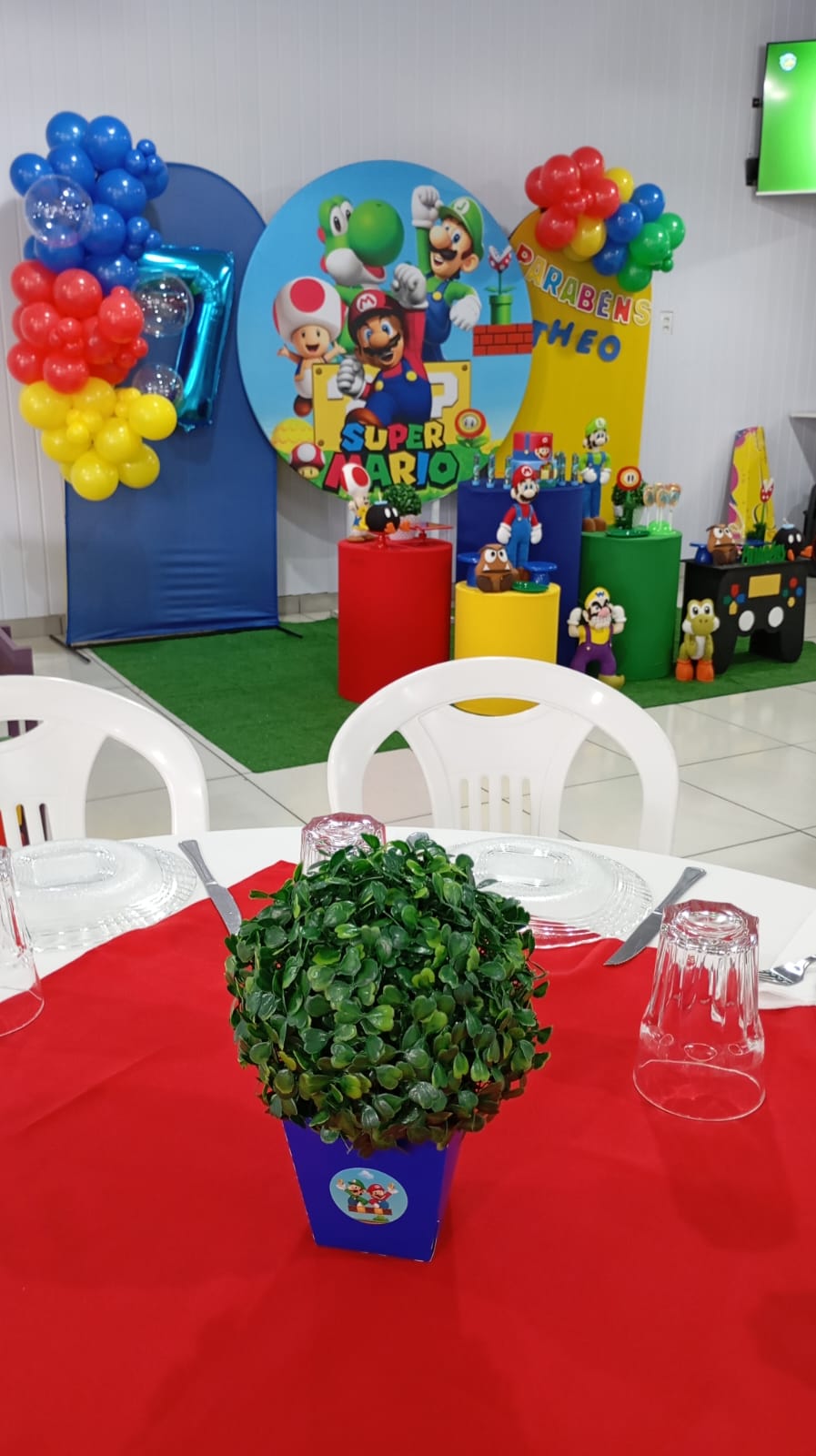 Mesas montadas no salão com decoração ao fundo